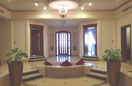 Entrada interior villa en Oman. Suelo en crema marfil con aplicaciones de marron emperador